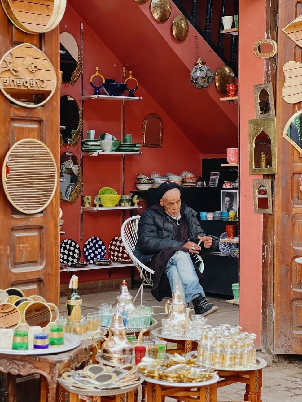 Artisan assis dans sa boutique de céramiques et de théières de la médina de Marrakech