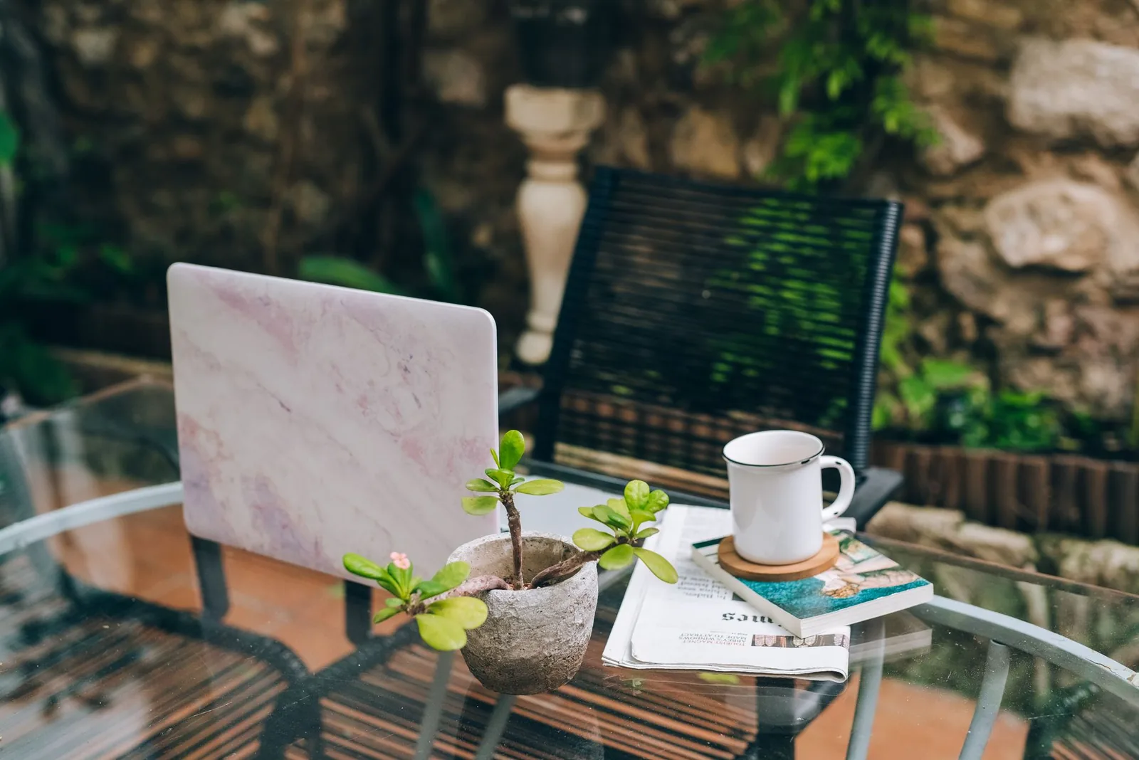 Ordinateur portable et café sur une table de jardin, travail en freelance au Maroc