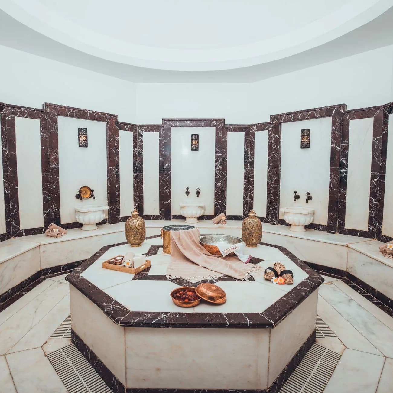 Hammam en marbre blanc et vasques traditionnelles dans le spa d'un hôtel de Marrakech