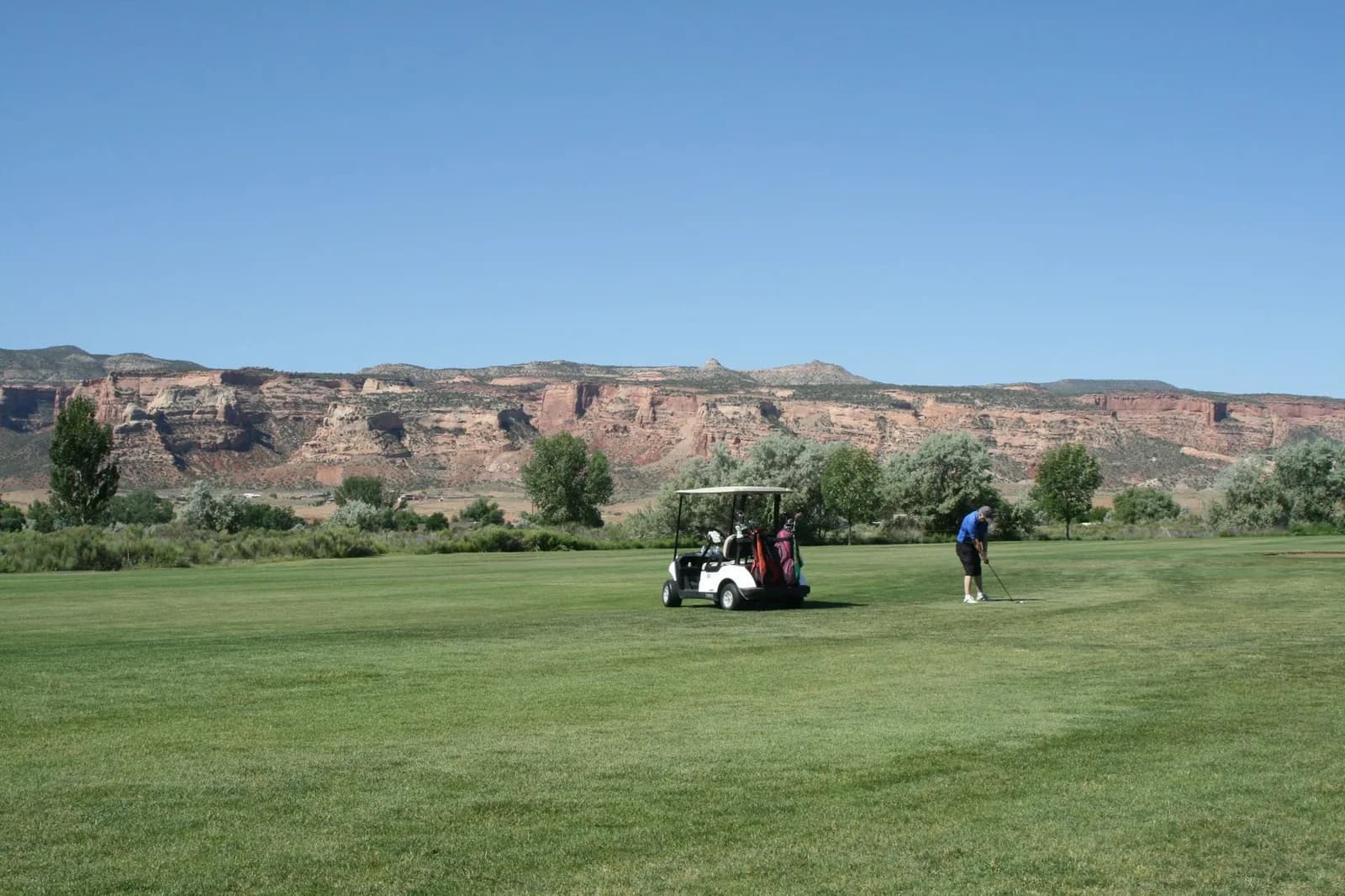 Golfeur sur un parcours de Marrakech avec des montagnes arides en arrière-plan