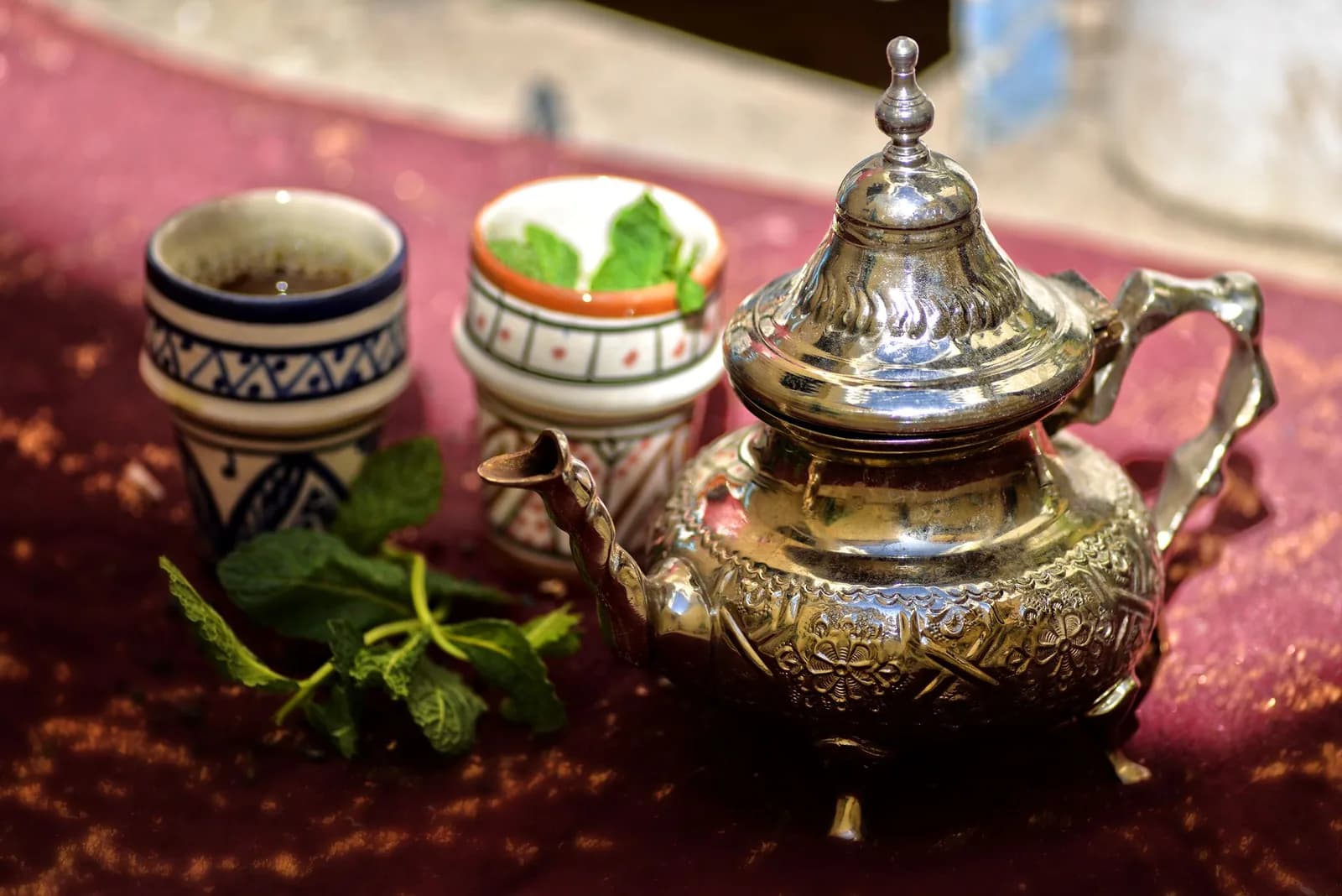 Théière en métal ciselé, verres décorés et menthe fraîche, service de thé à la menthe marocain