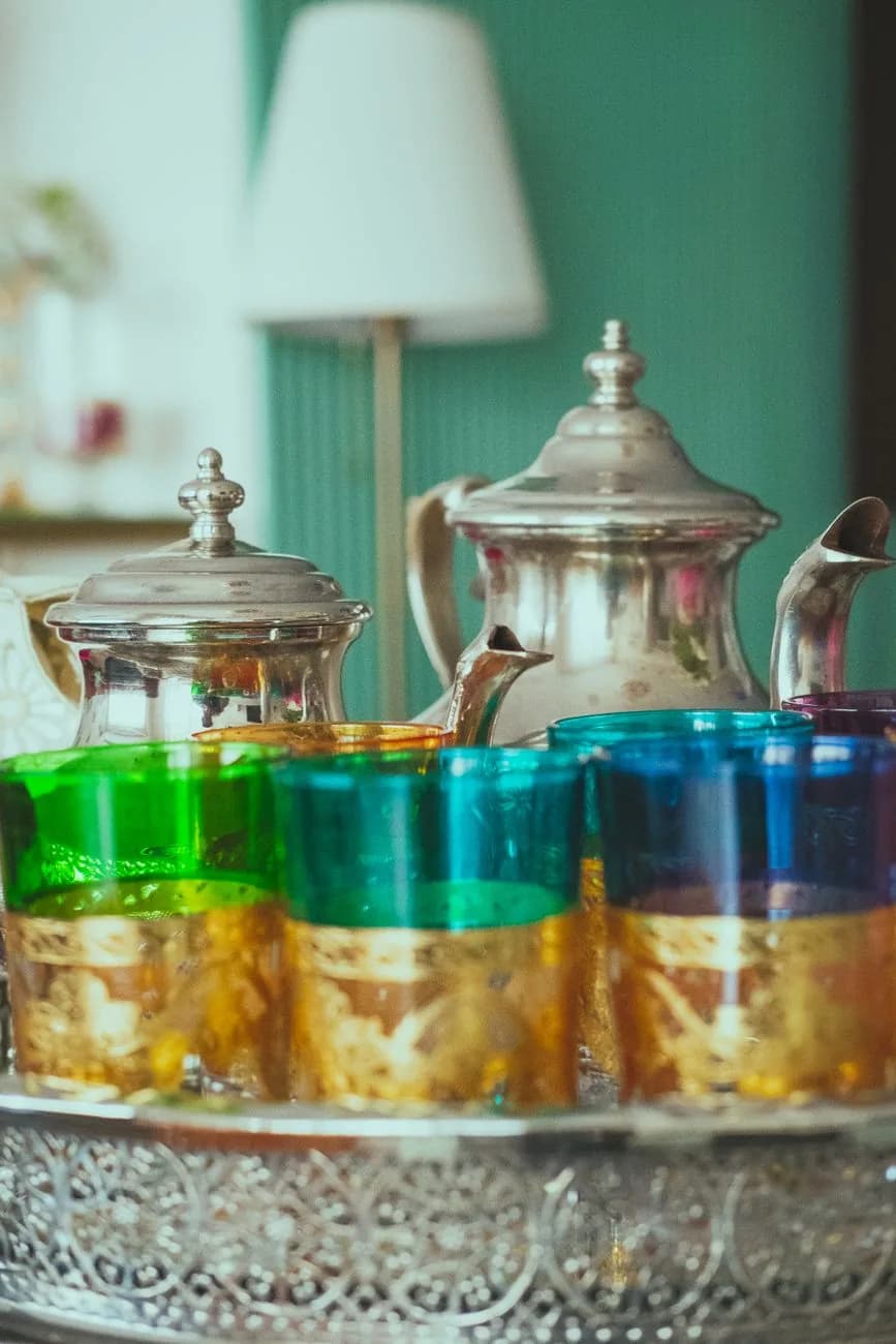 Plateau de thé à la menthe marocain avec théière en argent et verres colorés servis pour un invité