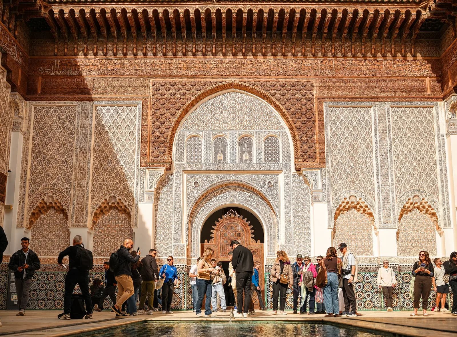 Groupes de visiteurs massés devant la salle de prière de la Medersa Ben Youssef en milieu de matinée, Marrakech