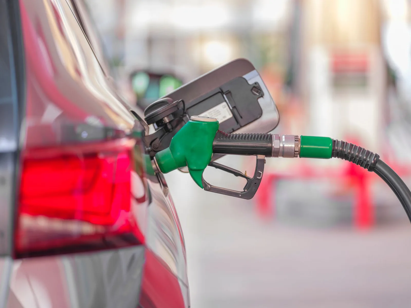 Pistolet de pompe vert engagé dans le réservoir d'une voiture pendant un plein de carburant