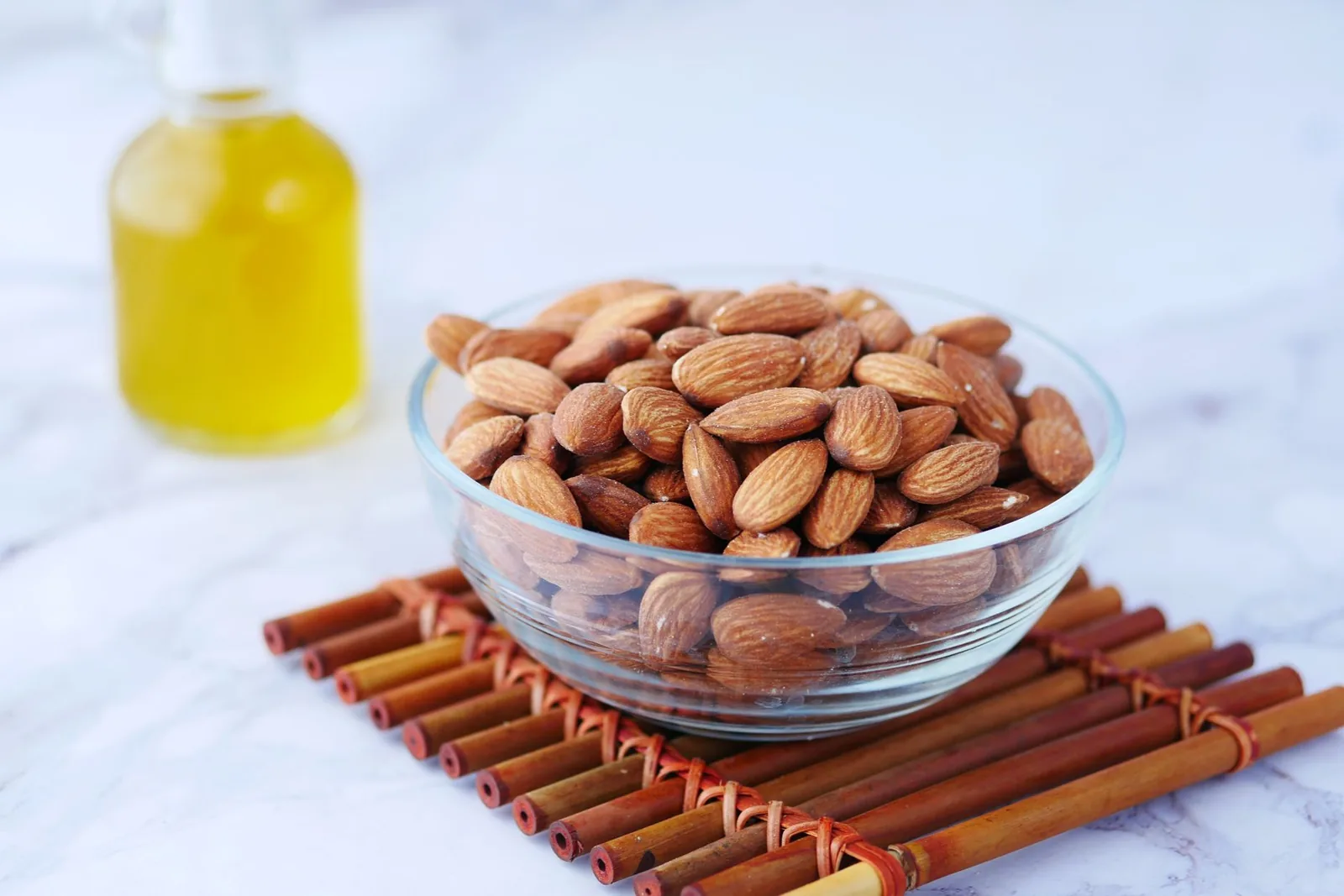 Bol d'amandes entières et flacon d'huile, les ingrédients de base de la recette de l'amlou marocain