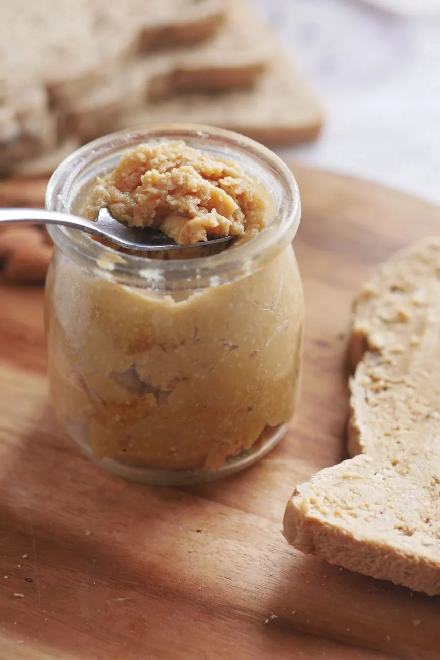 Bocal de pâte à tartiner aux amandes servi avec des tranches de pain, la façon la plus simple de déguster l'amlou