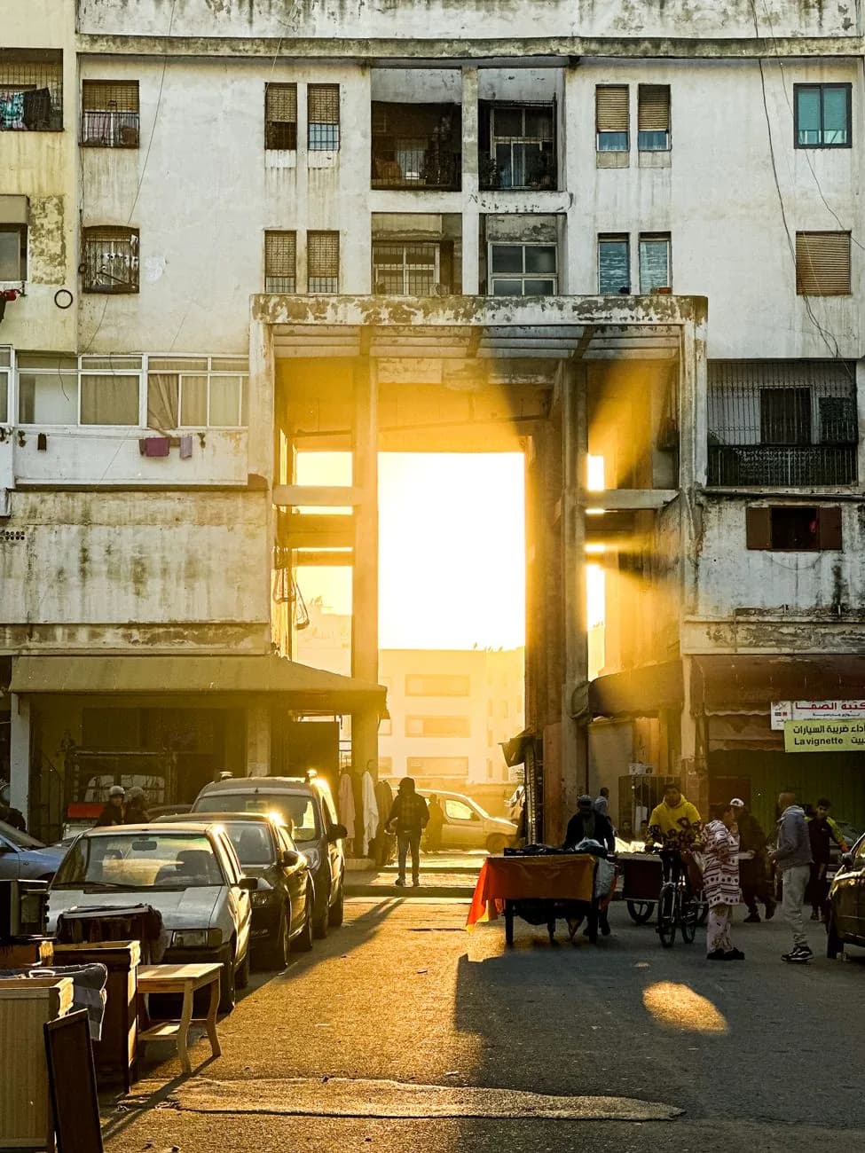 Rue d'un quartier populaire de Casablanca en fin de journée, étals et commerces de proximité