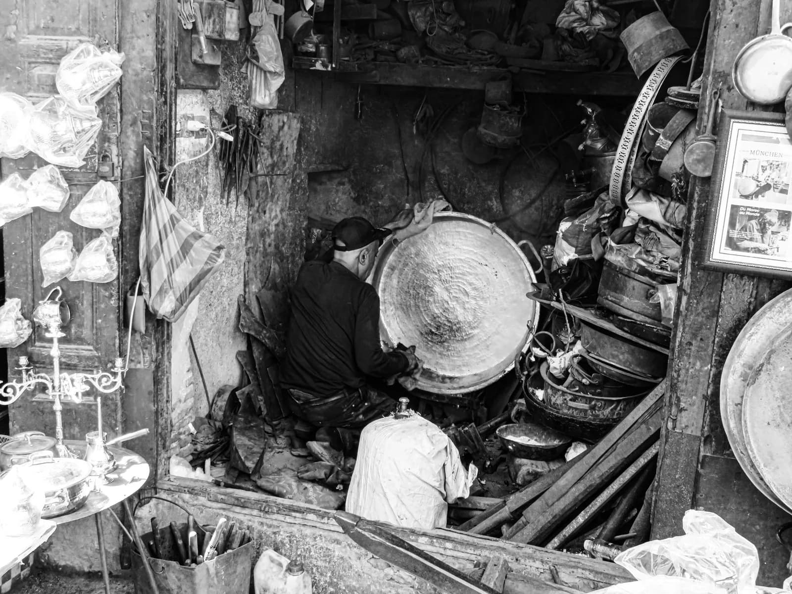 Dinandier marocain martelant un plateau de cuivre dans son atelier de la médina