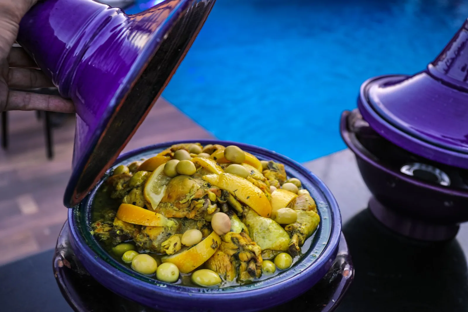 Tajine marocain de poulet au citron confit et aux olives vertes, couvercle soulevé