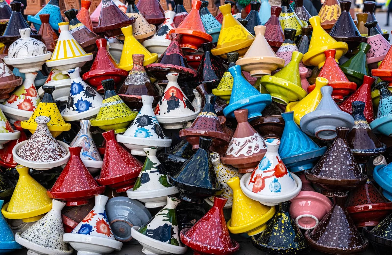 Empilement de tajines en céramique vernissée de toutes les couleurs sur un étal de poterie à Marrakech