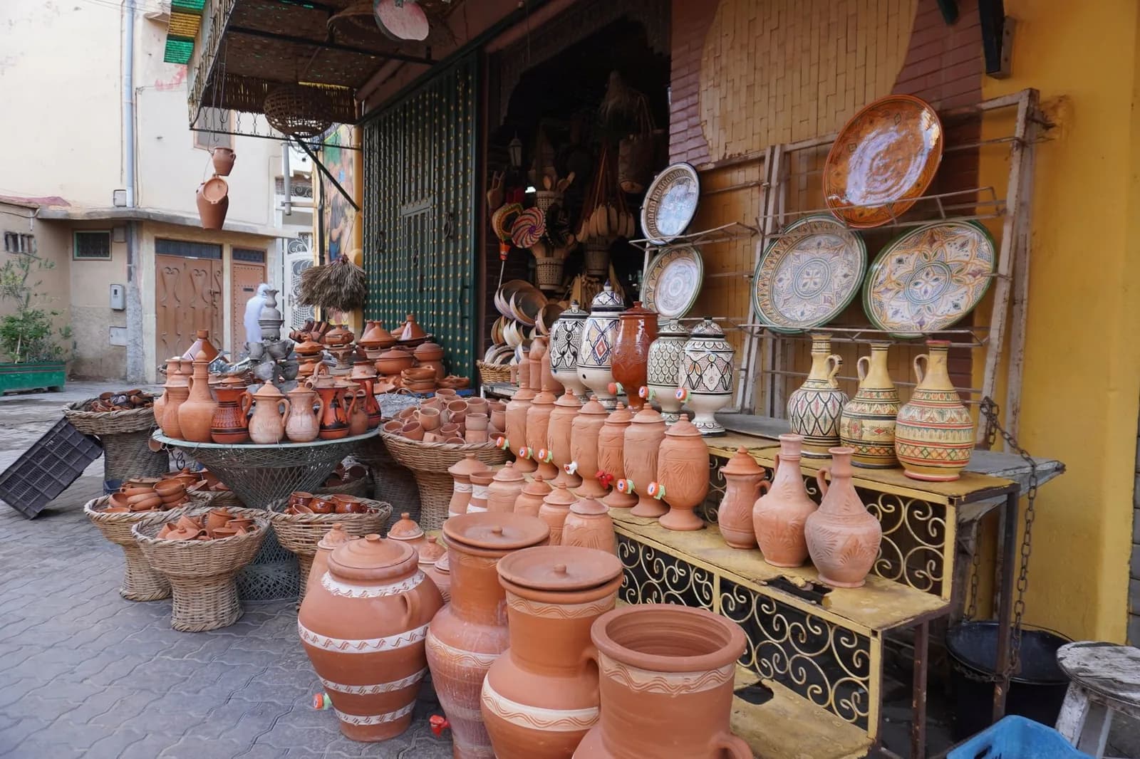 Jarres, cruches et plats en terre cuite exposés devant une boutique de poterie
