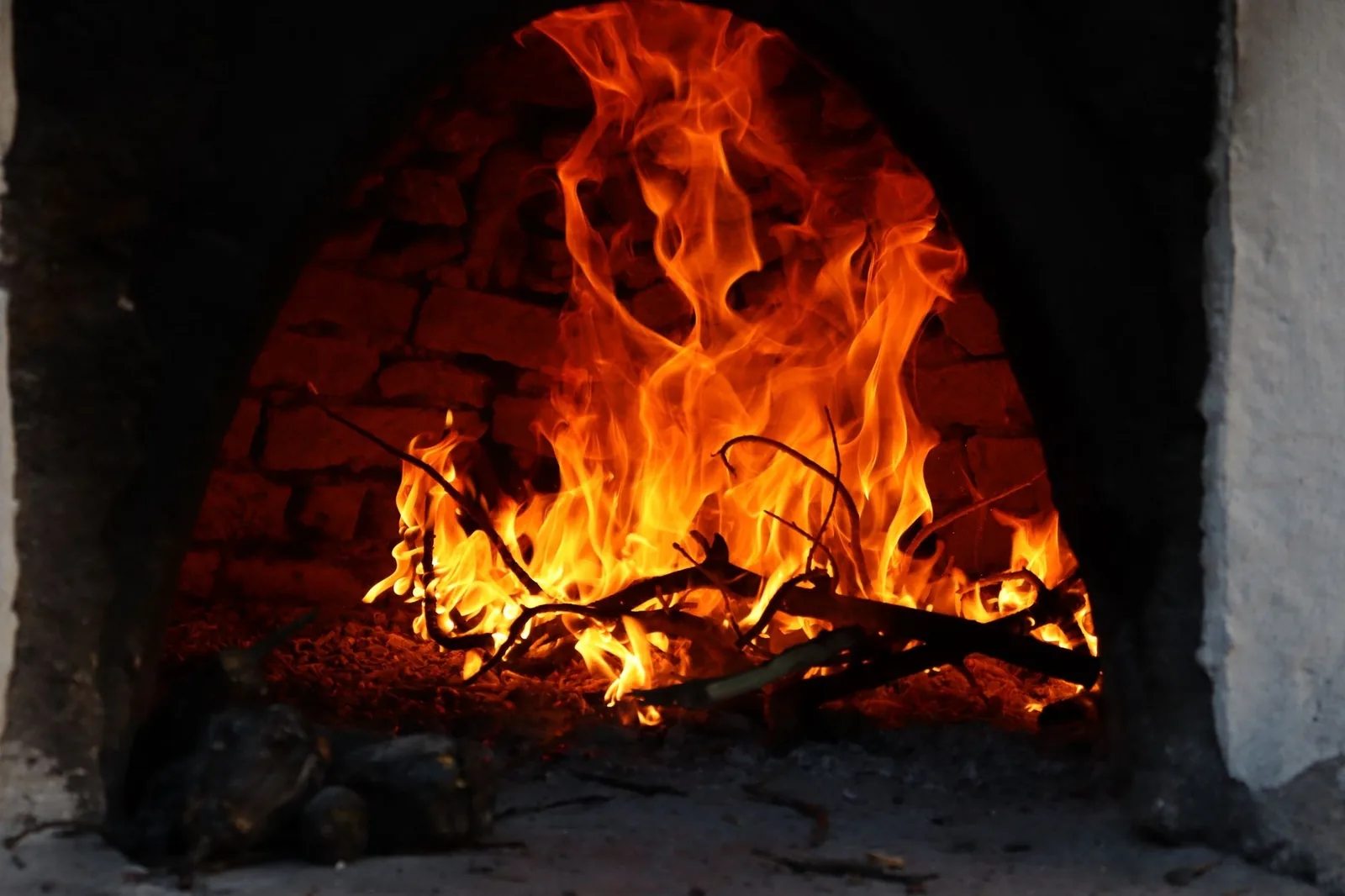 Feu de bois qui flambe dans un four en briques voûté