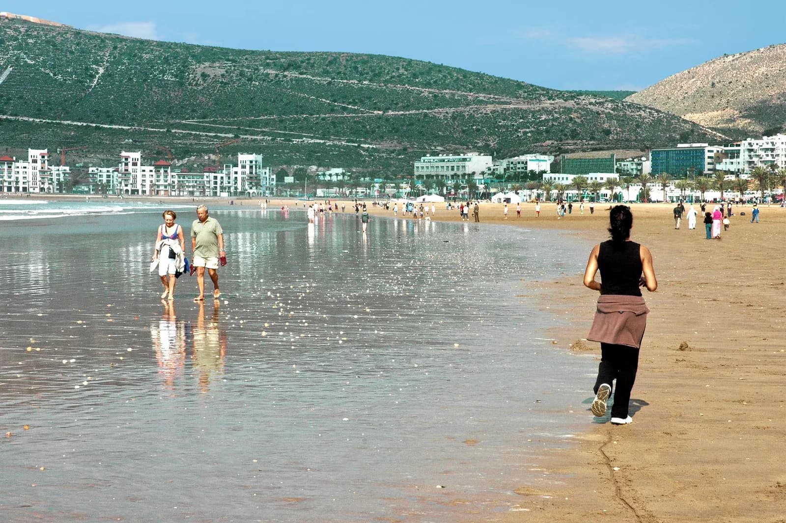 Couple de retraités marchant sur la plage d'Agadir face aux immeubles du front de mer
