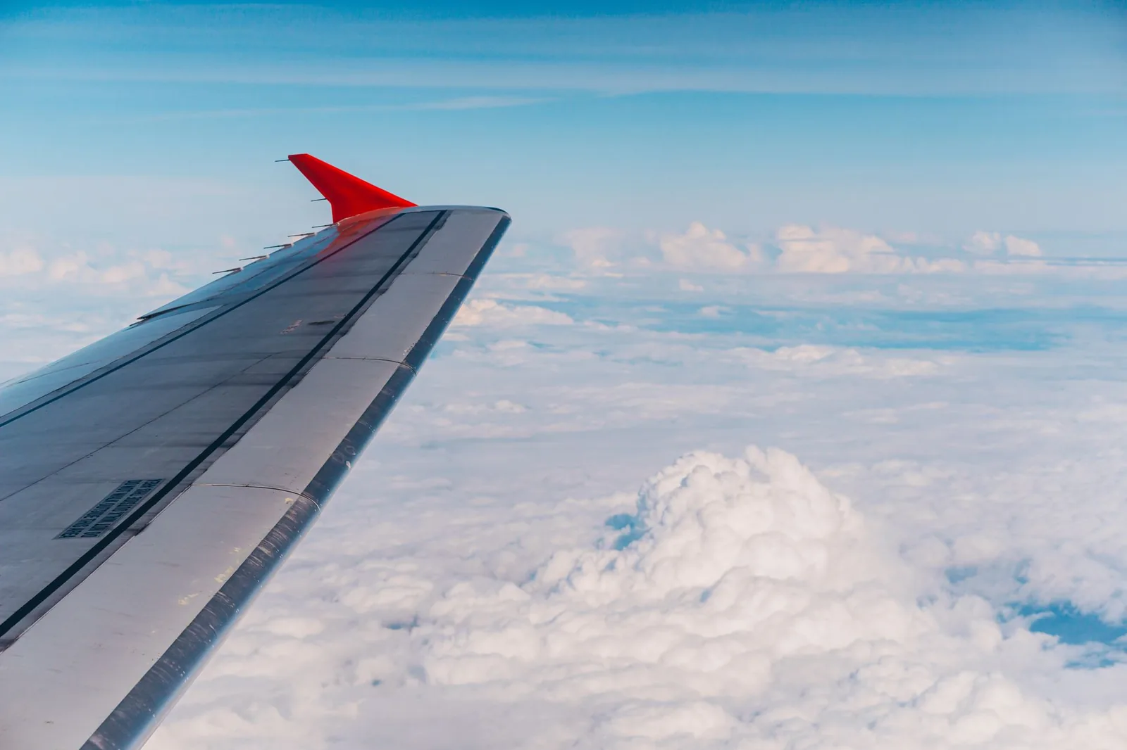 Aile d'avion au-dessus des nuages pendant la traversée entre Paris et Marrakech