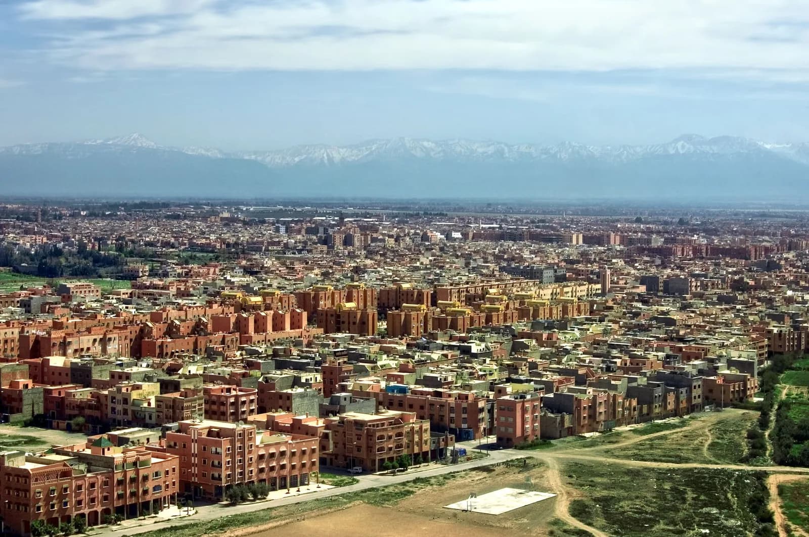 Vue aérienne de Marrakech à l'atterrissage, avec les sommets enneigés du Haut Atlas en arrière-plan